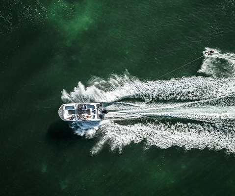 Overhead view of a Hurricane sport boat towing a wakeboarder. 