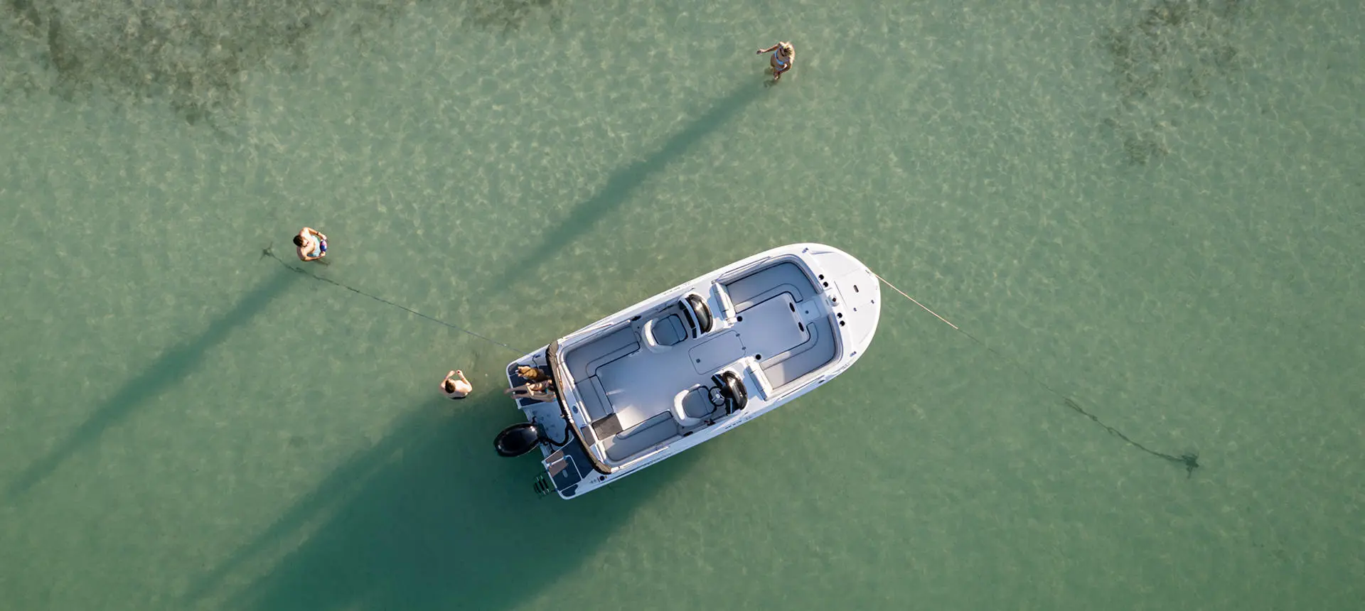 Aerial view of a Hurricane ocean boat floating near a sandbar with people enjoying the water around it.
