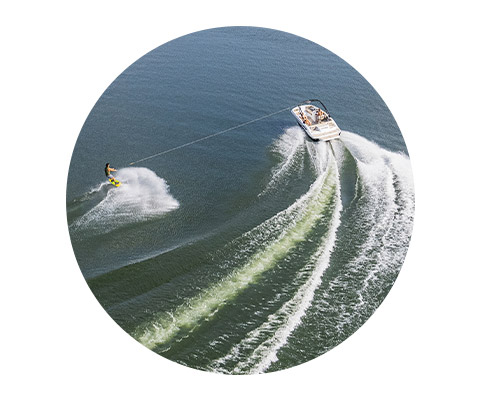 A man water skiing next to a Hurricane Boat