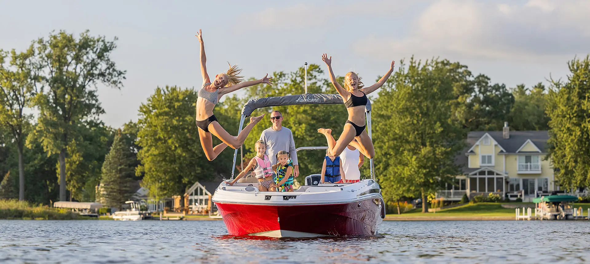 Two girls jumping from their Hurricane boat into the water
