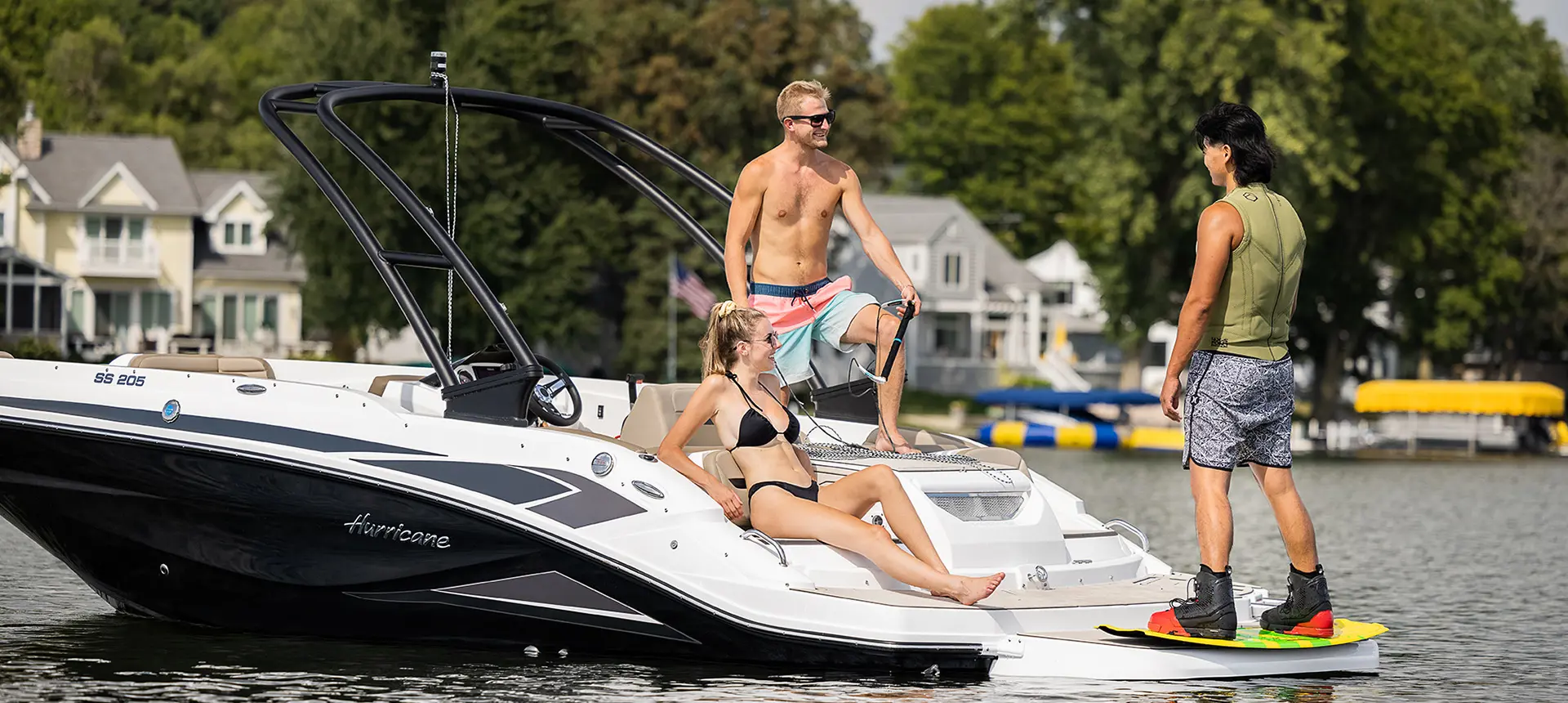 Three friends hanging out on a decked Hurricane boat in a lake