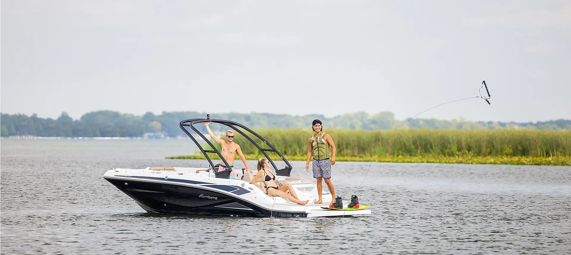 Three friends getting ready to wakeboard on a Hurricane boat