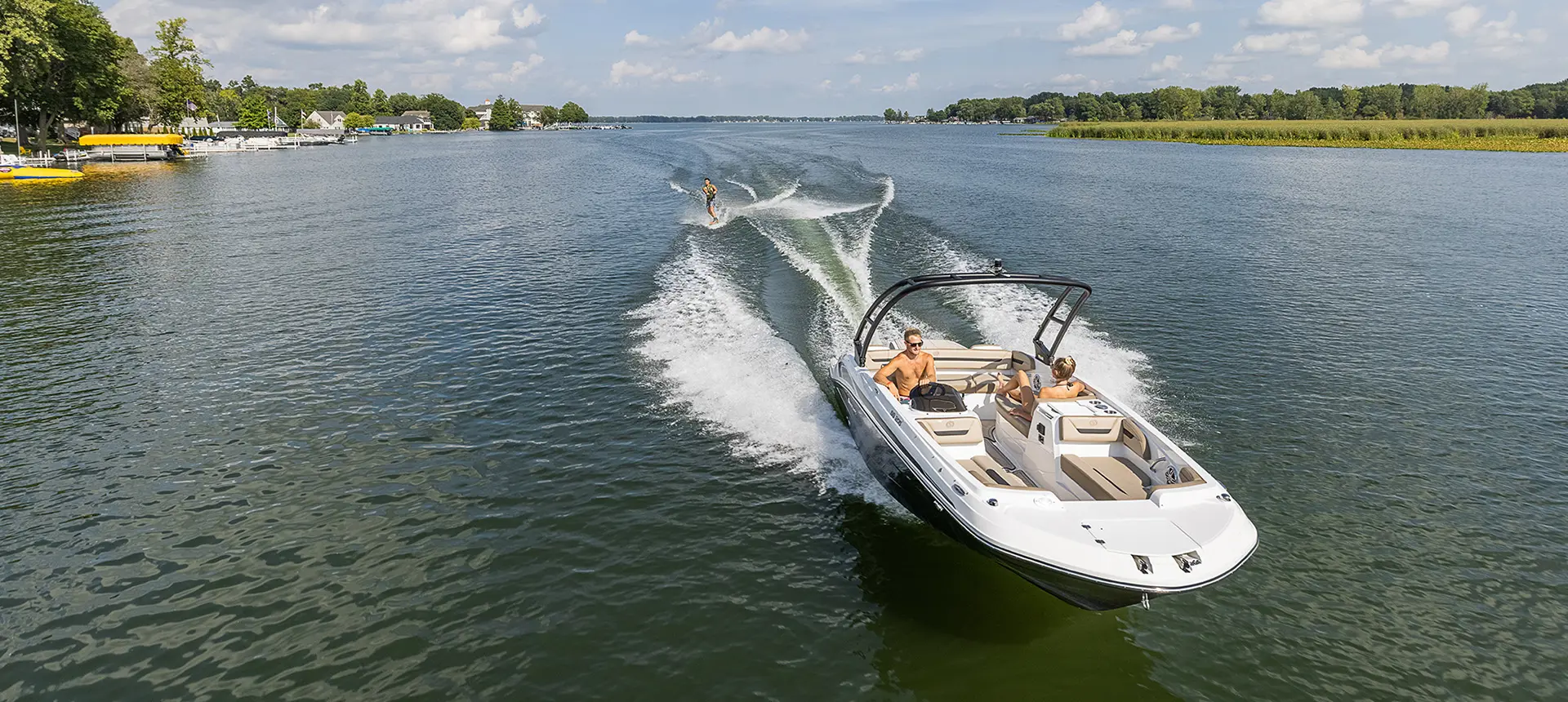 Front view of a Hurricane boat connected to a person wakeboarding on a lake