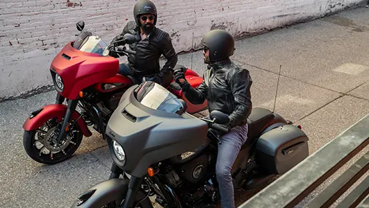 Deux hommes bavardant en enfourchant leur motos Indian stationnées
