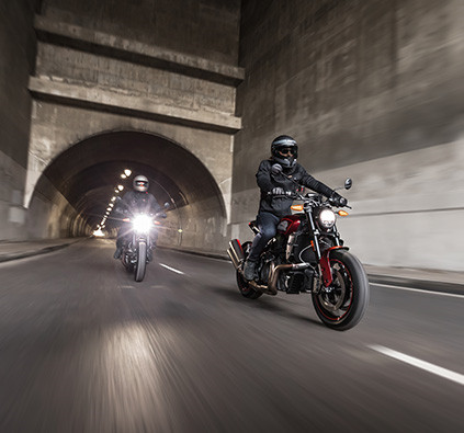 Two racers riding their Indian inside a tunnel