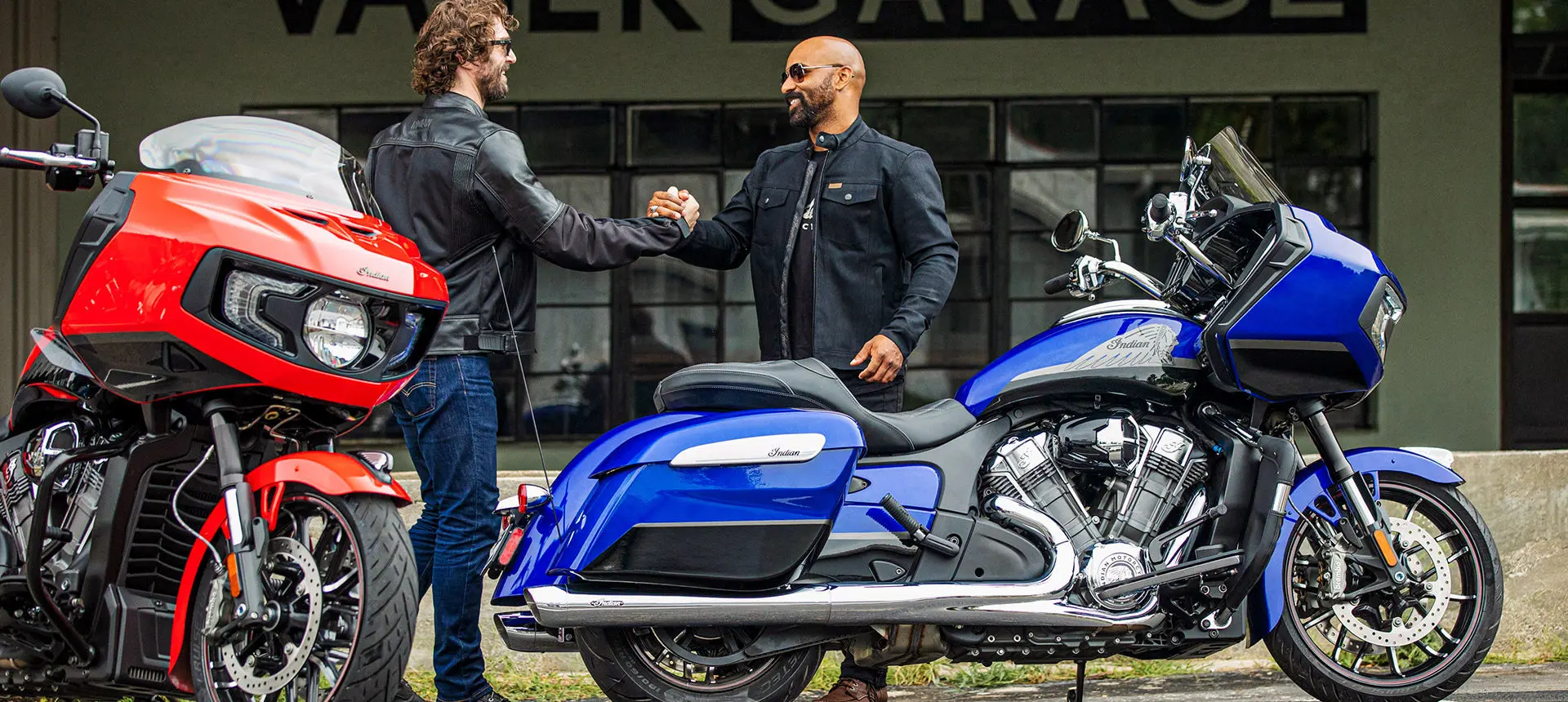 2 riders hanging out by their indian challenger motorcycles