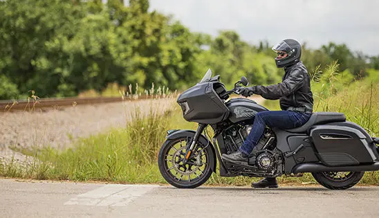 man riding an indian challenger dark horse motorcycle