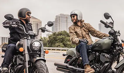 2 riders smiling on their indian chief dark horse motorcycles