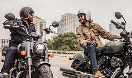 2 riders smiling on their indian chief dark horse motorcycles