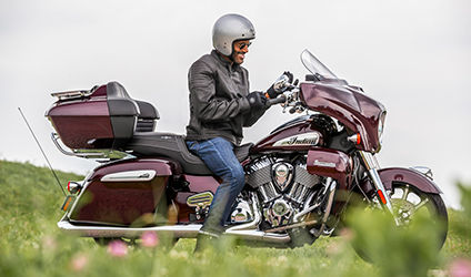 man putting on his gloves before riding his indian roadmaster limited motorcycle