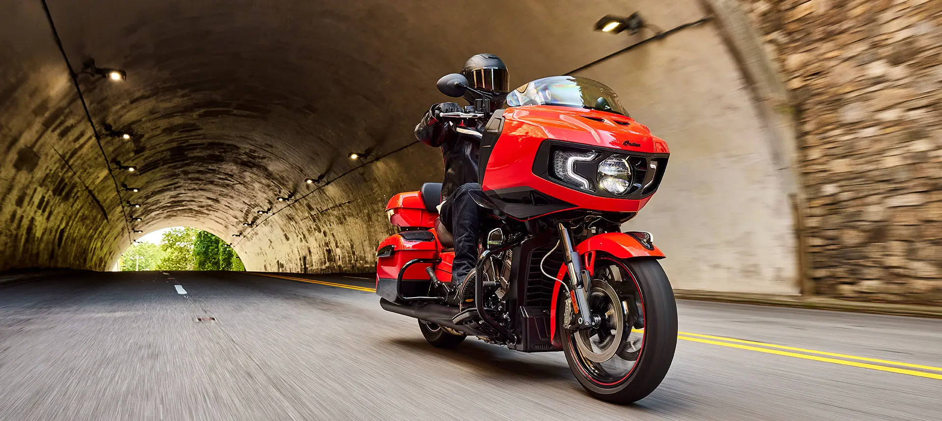 person riding an indy red/black metallic indian challenger dark horse motorcycle