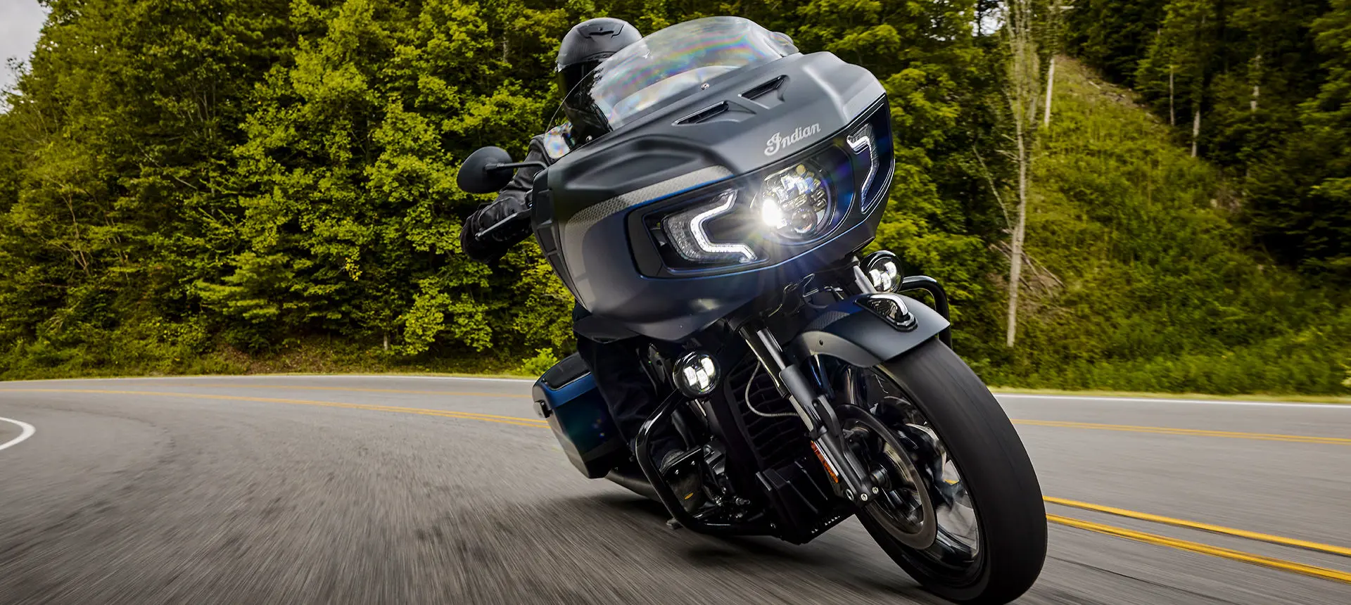 person riding a sapphire blue smoke indian challenger elite motorcycle