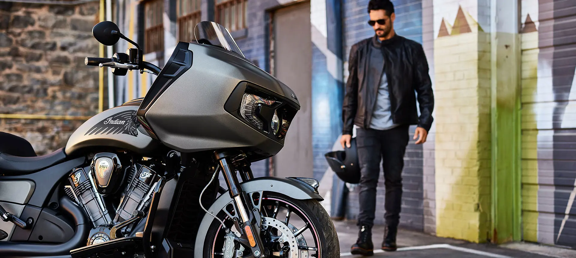 man walking towards an indian challenger motorcycle
