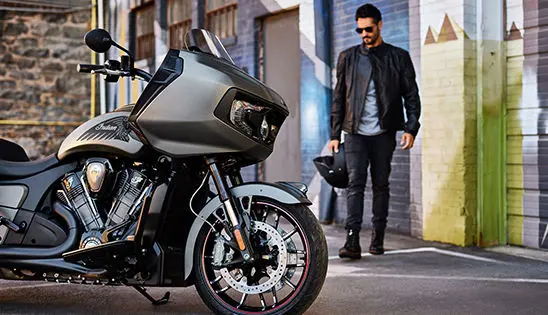 man walking towards an indian challenger motorcycle
