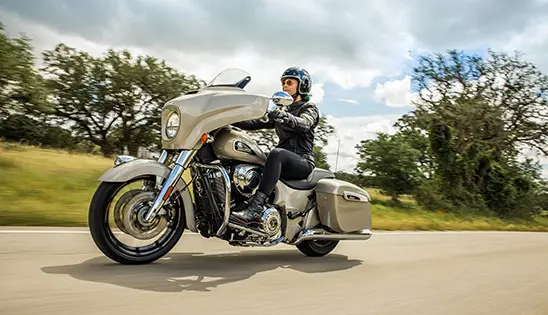 woman riding a silver quartz metallic indian chieftain limited motorcycle