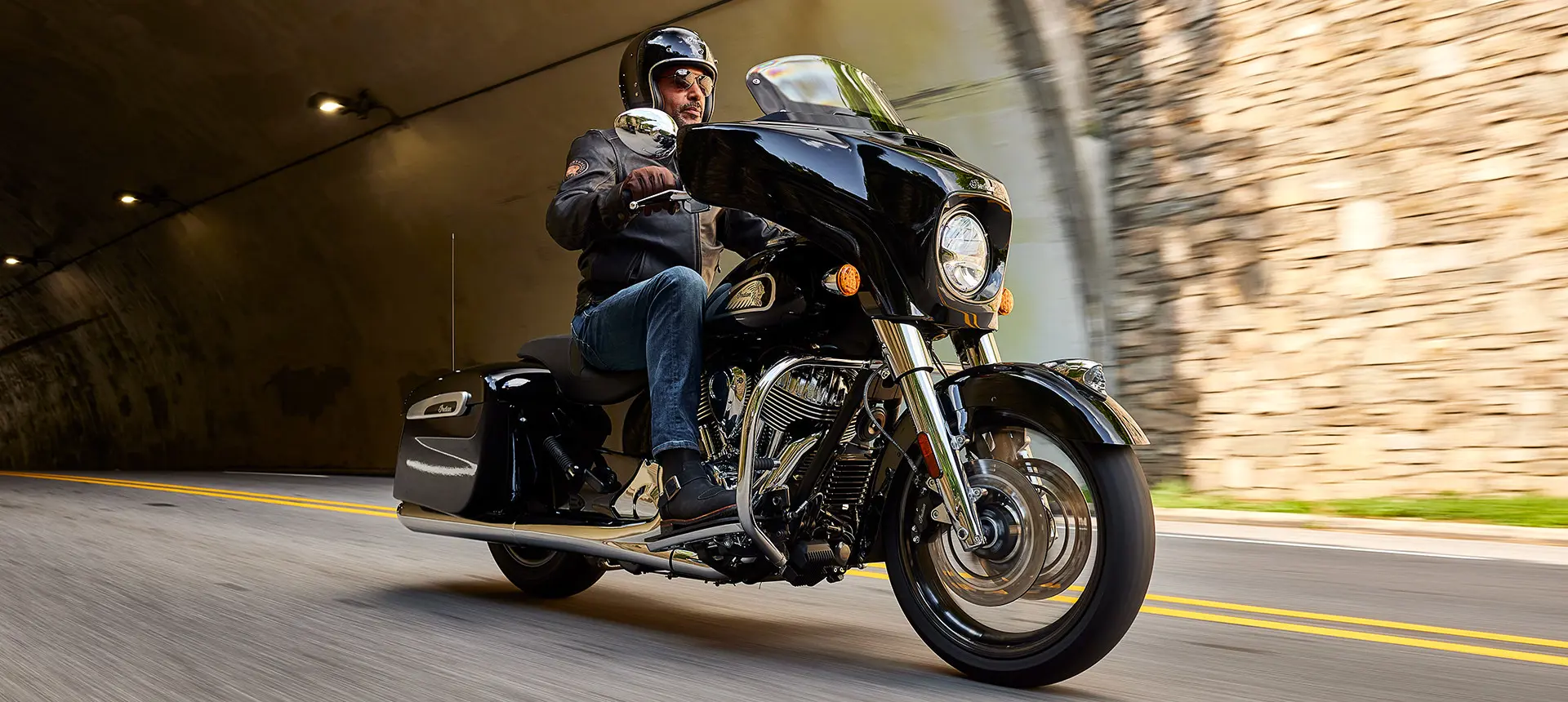 man riding a black metallic indian chieftain motorcycle