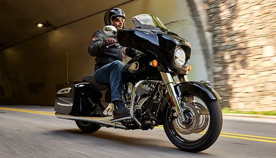man riding a black metallic indian chieftain motorcycle