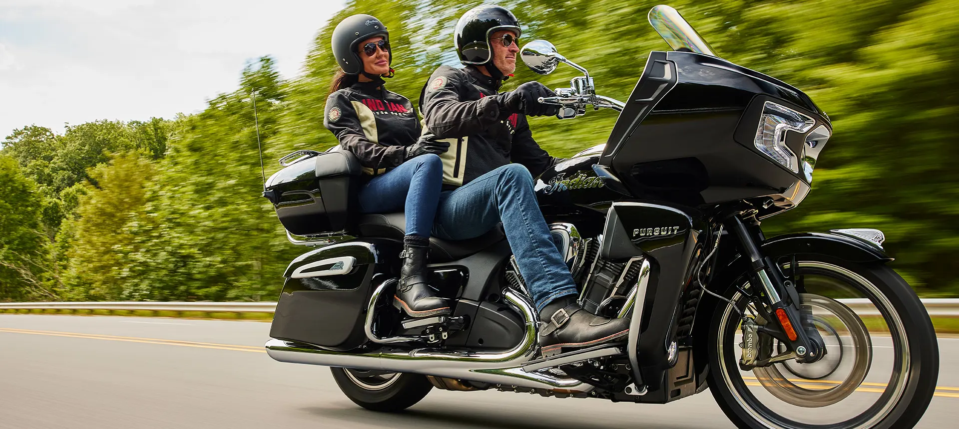 a couple riding an indian pursuit limited motorcycle