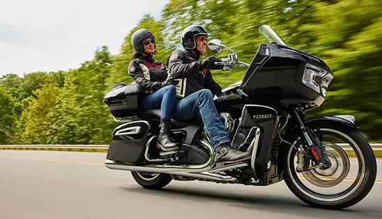 a couple riding an indian pursuit limited motorcycle