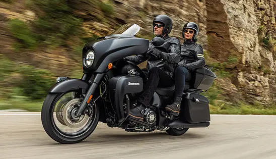 a couple cruising on a black smoke indian roadmaster dark horse motorcycle