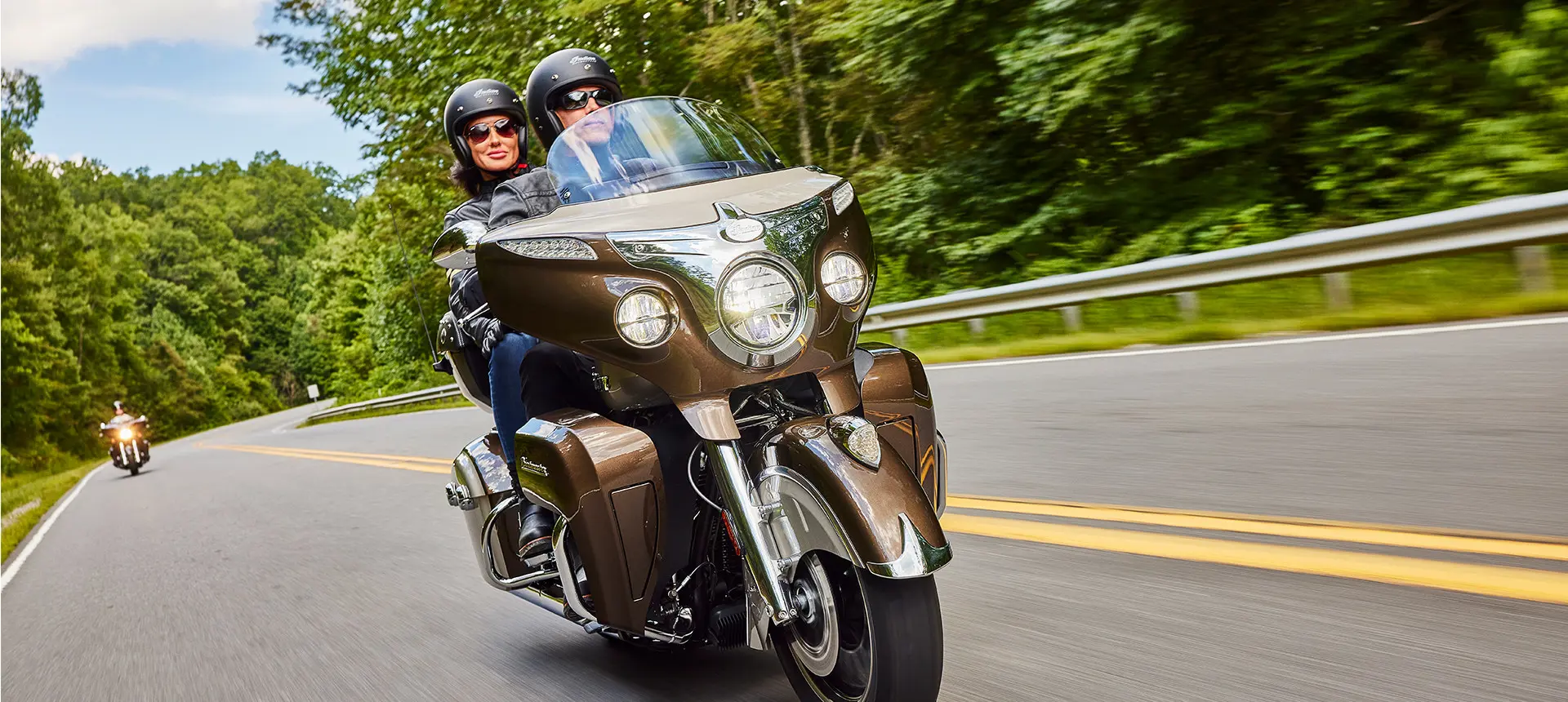 a couple cruising on the highway on an indian roadmaster motorcycle