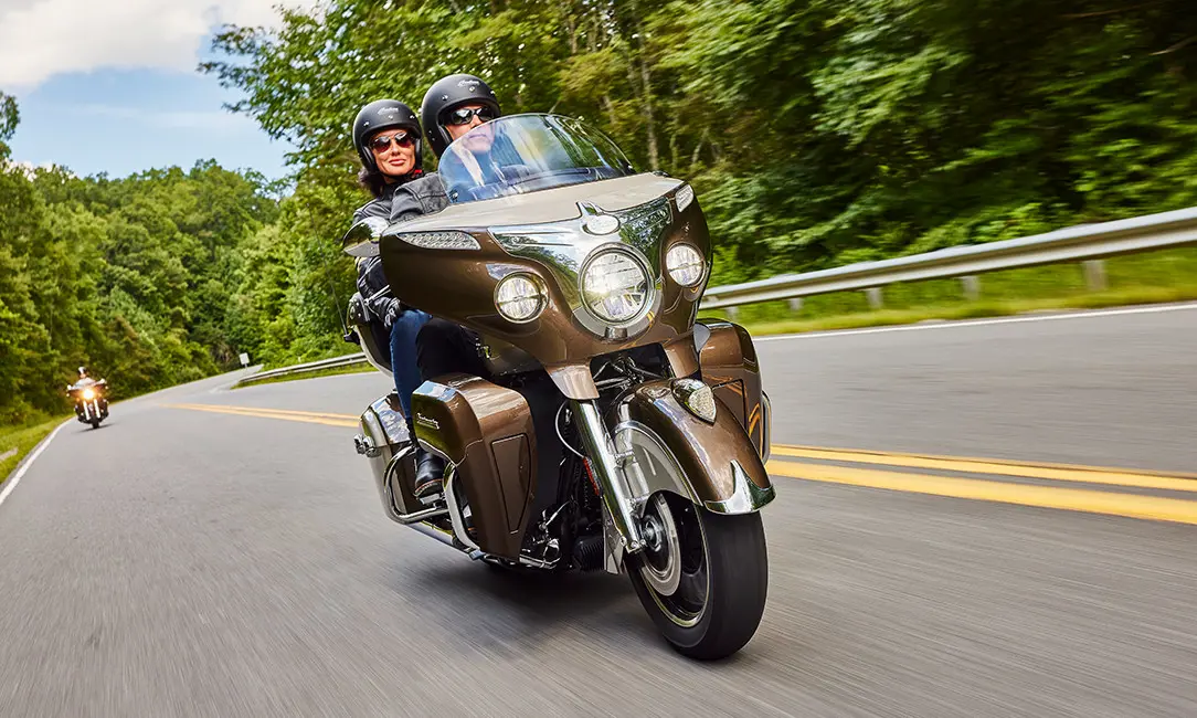 a couple cruising on the highway on an indian roadmaster motorcycle