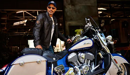 man standing near a indian springfield motorcycle