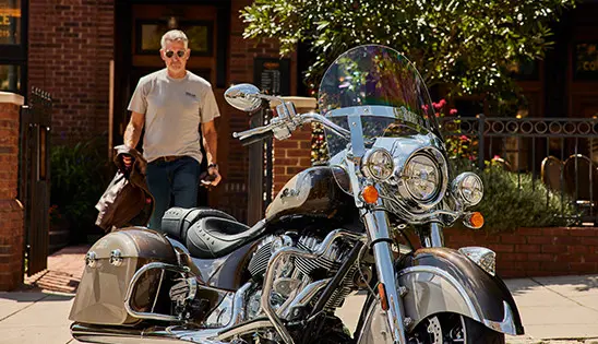 man walking towards an indian springfield motorcycle