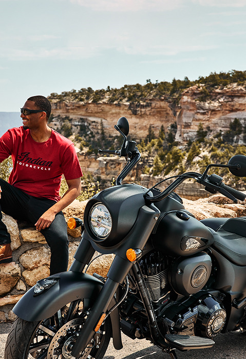man sitting near his indian springfield motorcycle