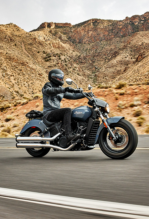 person riding an indian scout sixty motorcycle down the highway