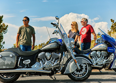 trois personnes debout près de leurs motos indian motorcycle