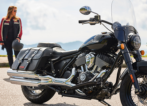 woman standing behind an indian super chief motorcycle