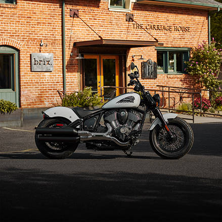 Moto bobber noire et blanche avec des garde-boue en queue de canard.