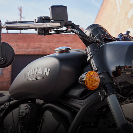Moto bobber dépouillée avec un seul phare avant. 