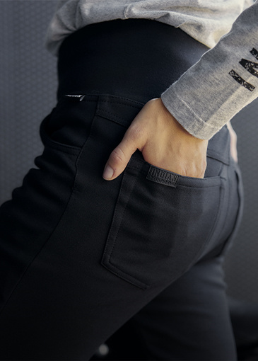 Woman putting hand in back pocket of her Indian Motorcycle riding jeans. 