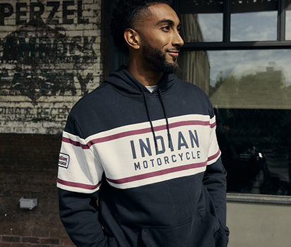 Man wearing navy blue Indian Motorcycle hoodie smiling and looking to the right.