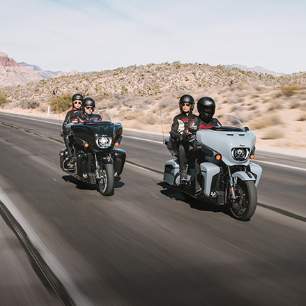 Two Indian touring motorcycles cruising down the highway showcasing their high-performance capabilities.