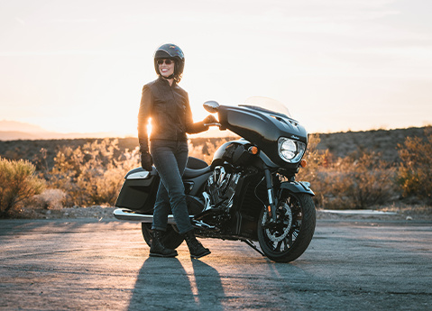 Una mujer con casco sonríe después de un paseo en su motocicleta 2025 Indian Chieftain PowerPlus.