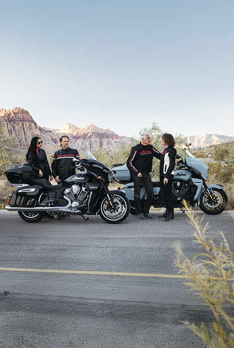 2 couples standing near their 2025 Indian Roadmaster PowerPlus Dark Horse motorcycle and 2025 Indian Roadmaster PowerPlus Limited motorcycle.