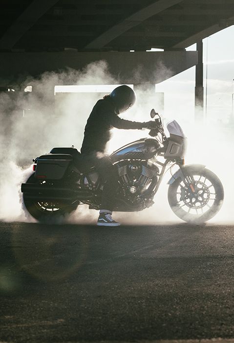 Persona sentada en una motocicleta cruiser 2025 Indian Sport Chief RT con humo rodeándola.
