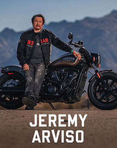 Jeremy Aviso leaning against Indian Motorcycle in the desert.