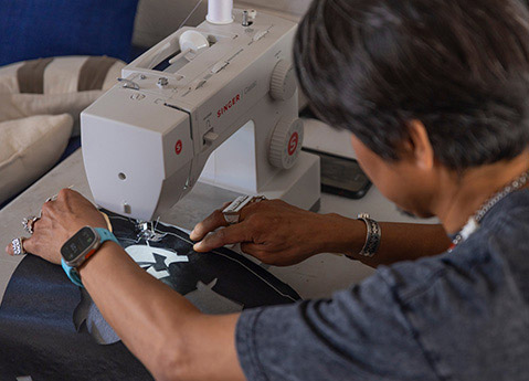 Jeremy Arviso using sewing machine to work on Indian Motorcycle RVSO collection garment.