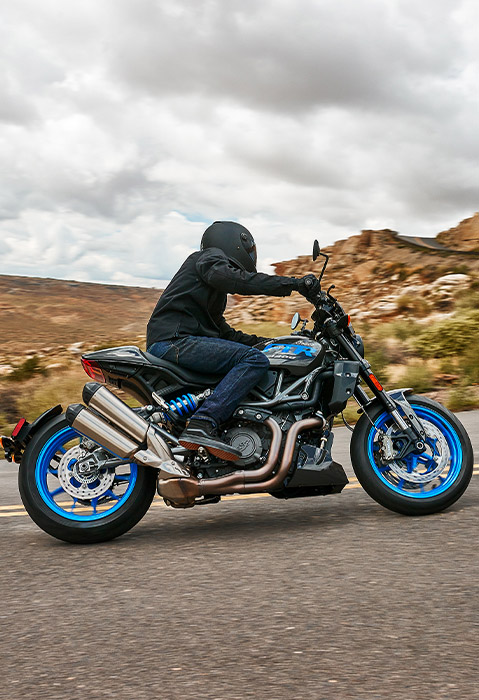 Person riding an Indian FTR Sport standard-style motorcycle on the highway.