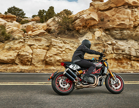 Person riding an Indian FTR R Carbon standard-style motorcycle.
