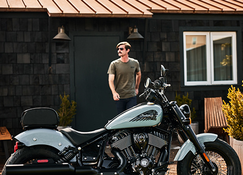 Man walking towards a 2025 Indian Chief Bobber Dark Horse cruiser motorcycle.