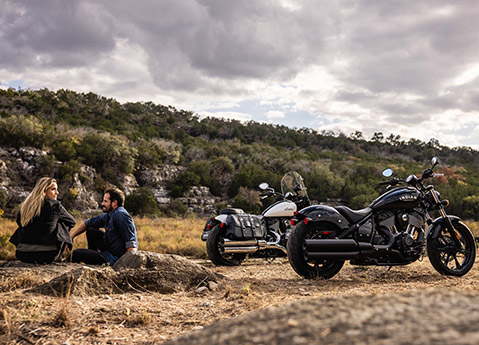 Couple se détendant sur des rochers après une randonnée sur leurs motos cruiser Indian Chief.