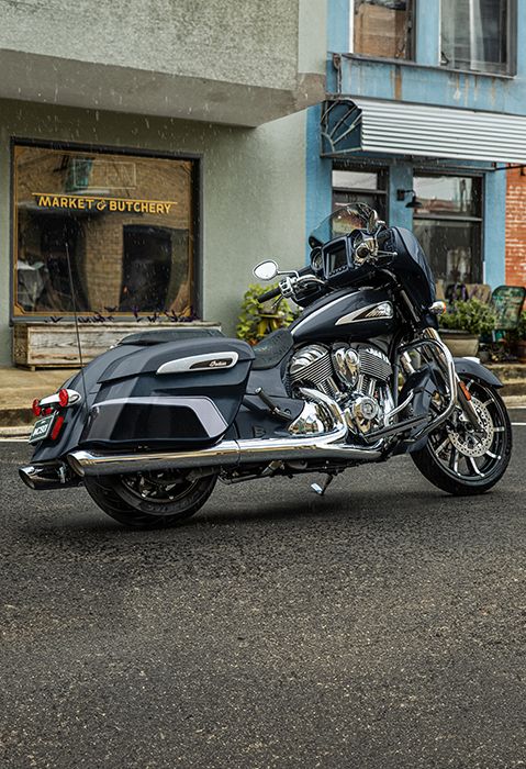 Side profile of a 2025 Indian Chieftain Limited bagger motorcycle in Blue Dusk parked on a city street.