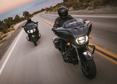 A 2025 Indian Chieftain PowerPlus Dark Horse motorcycle and 2025 Indian Chieftain PowerPlus Limited motorcycle cruising on the highway.