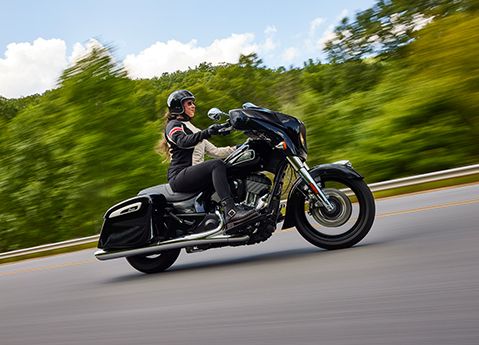 Side profile of a woman riding a 2025 Indian Chieftain bagger motorcycle.