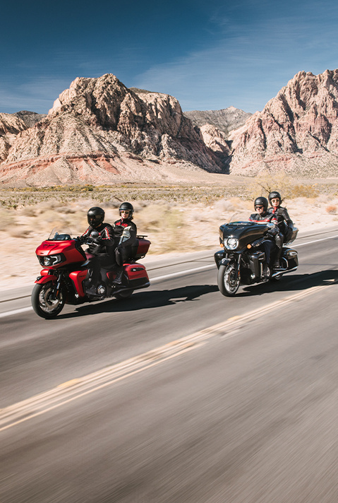 2 couples riding their 2025 Indian Pursuit Limited and 2025 Indian Pursuit Dark Horse motorcycles on the highway.